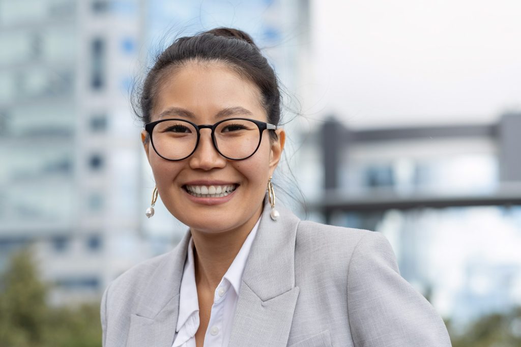 young professional woman wearing eyeglasses at Oakville clinic, smiling after dry eye treatment